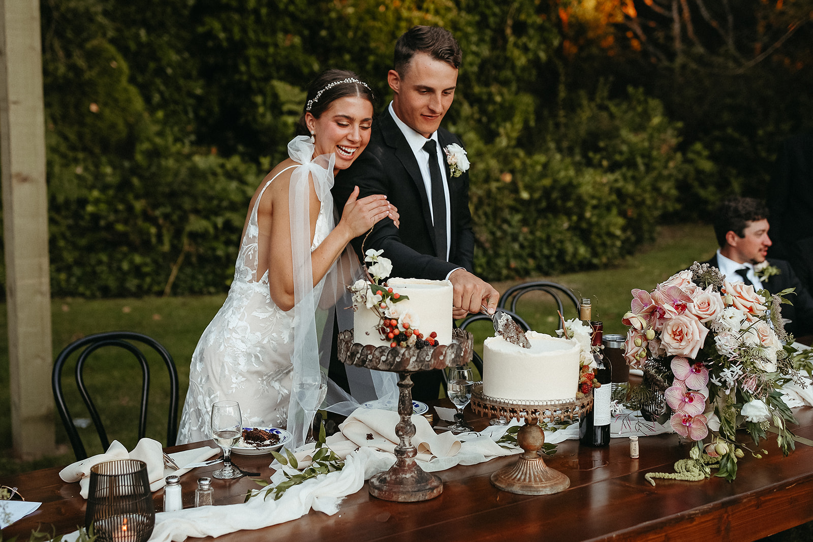 Bride and groom cutting cake at chic garden party wedding